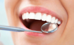 dental mirror in woman's mouth
