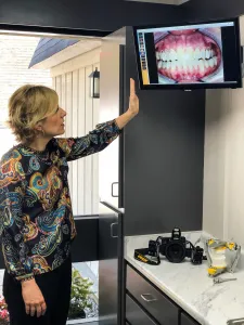 staff showing closeup of teeth on TV monitor